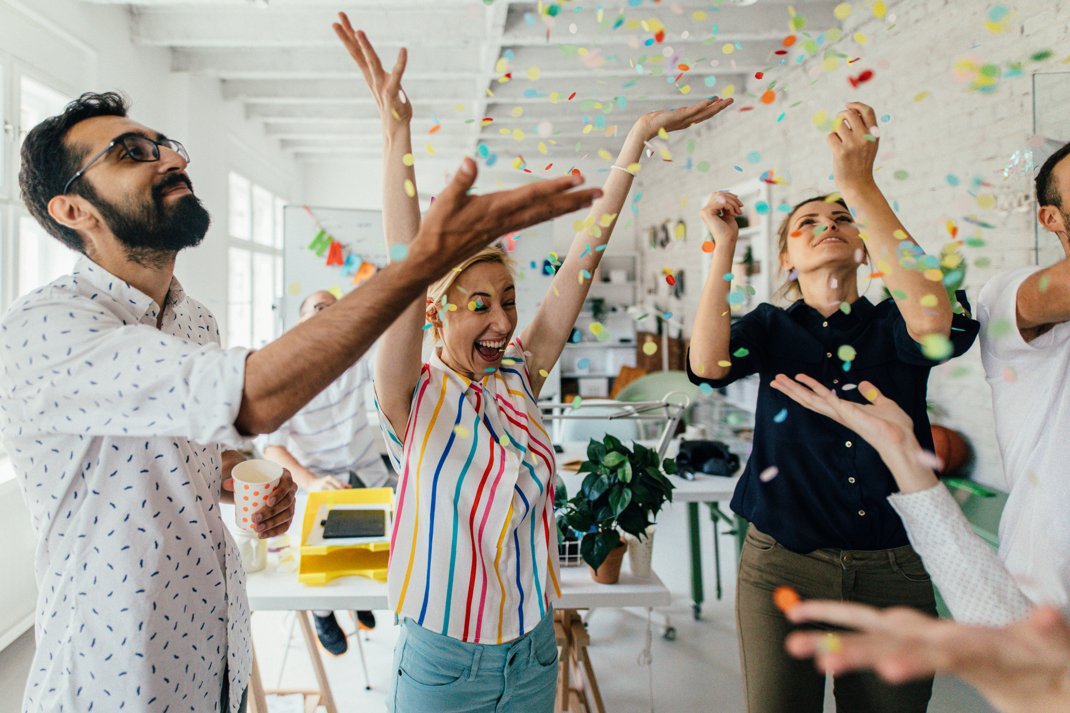 a group of coworkers having a happy occasion and celebrating together in their office